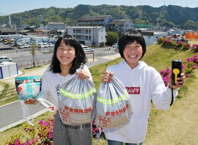 非常用の持ち出し袋を手に笑顔の田渕凛海さん（左）と山本明日奏さん（高知市竹島町）