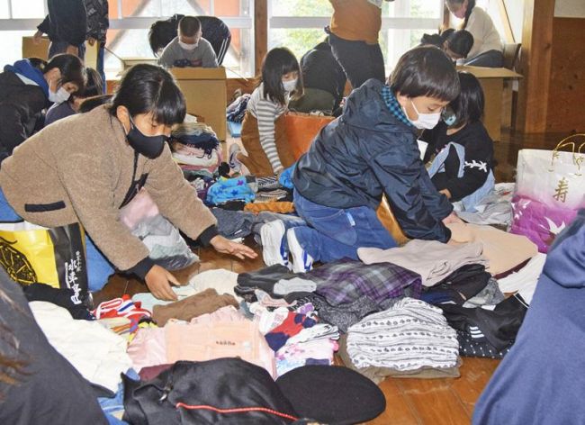 影野小校区で集めた子ども服を整理する児童（四万十町の影野小学校）