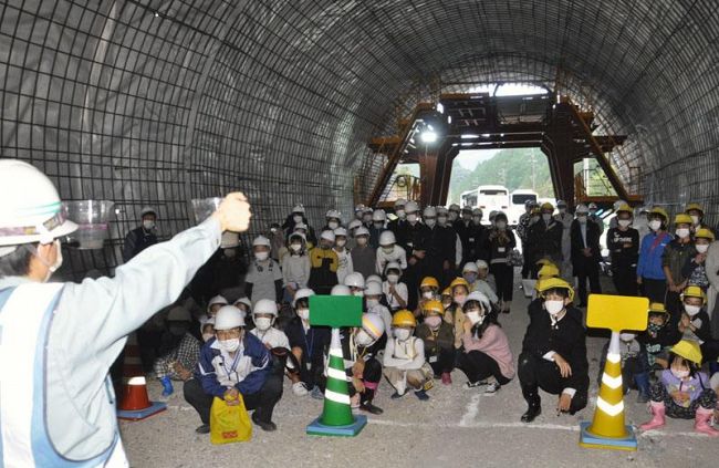 貫通した明神口トンネルの工事現場を見学する子どもたち（安田町船倉）