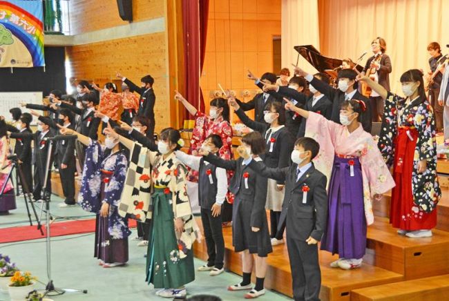 山下俊輔さんらと共に完成した曲を振り付きで歌う６年生たち（高知市の第六小）