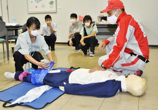 応急手当て講習で患部の固定を練習する防災いのぐ記者ら(高知新聞社)