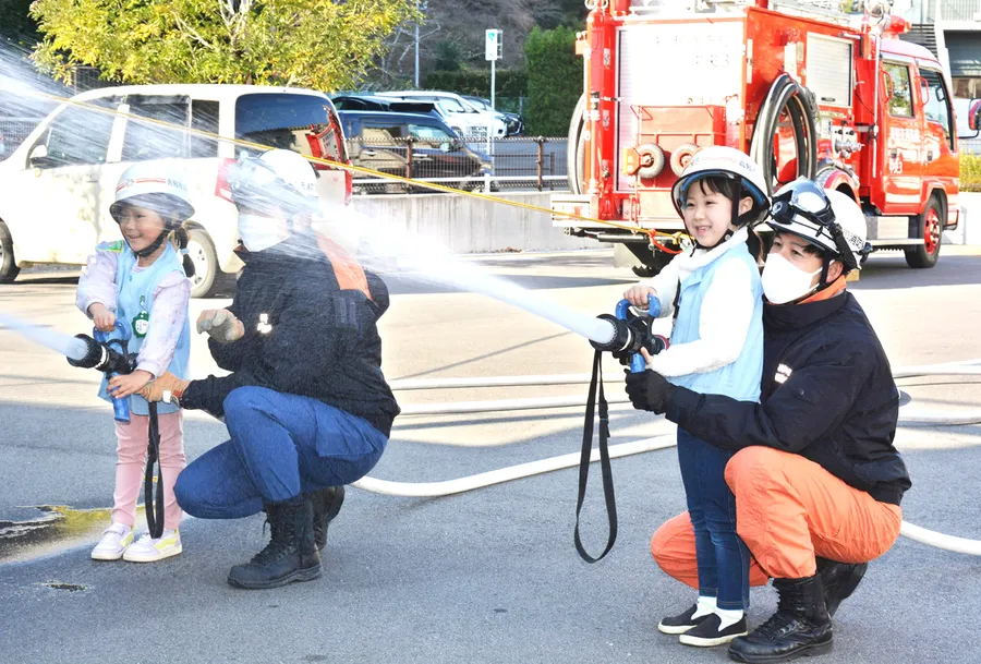 消防隊員と一緒に放水する園児（高知市中央消防署）
