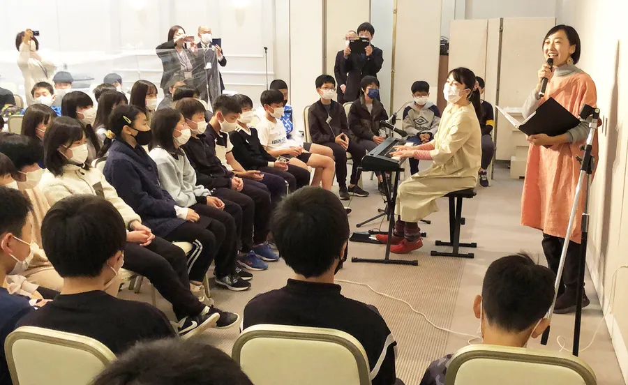 昨年１１月、広島市のホテルで大篠小６年生に完成した歌を初披露する（右から）瀬戸麻由さん、う～みさん