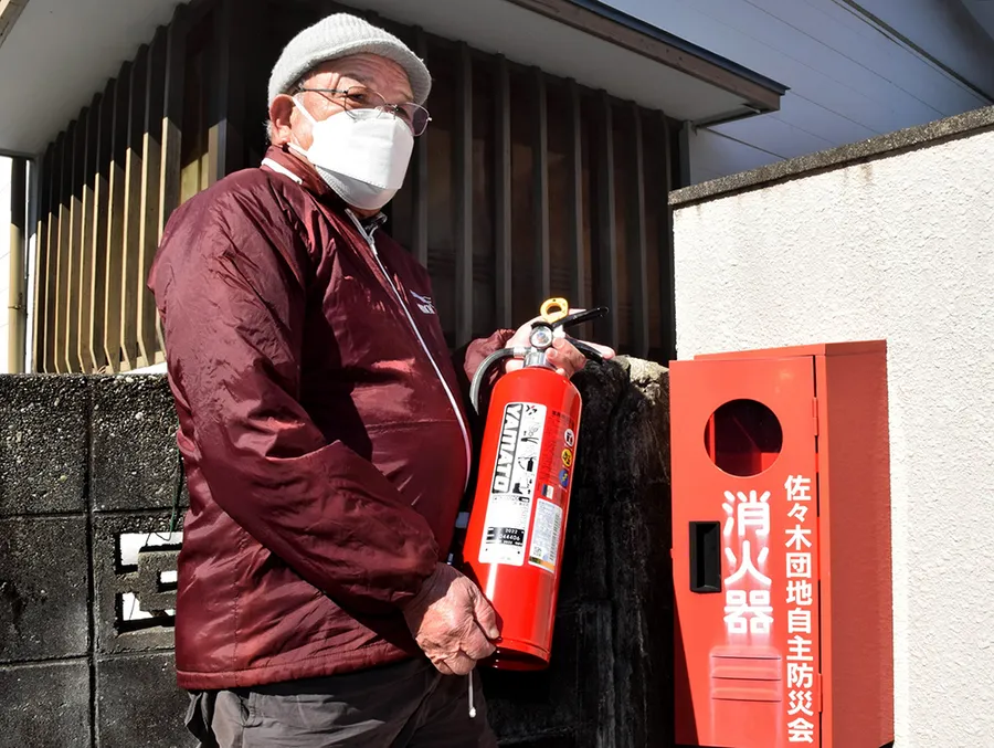 火災後に取り換えた消火器を持つ徳川博康さん（高知市佐々木町）
