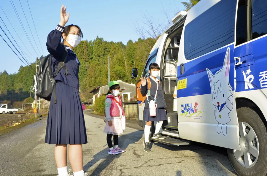 中学最後の日、家族らに見送られてバスに乗る竹井清香さん（左）＝香南市夜須町羽尾