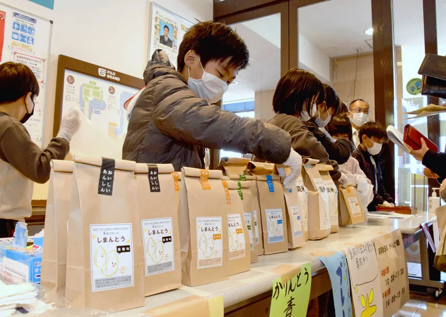 米と米粉かりんとうを売る具同小学校の児童（四万十市具同）