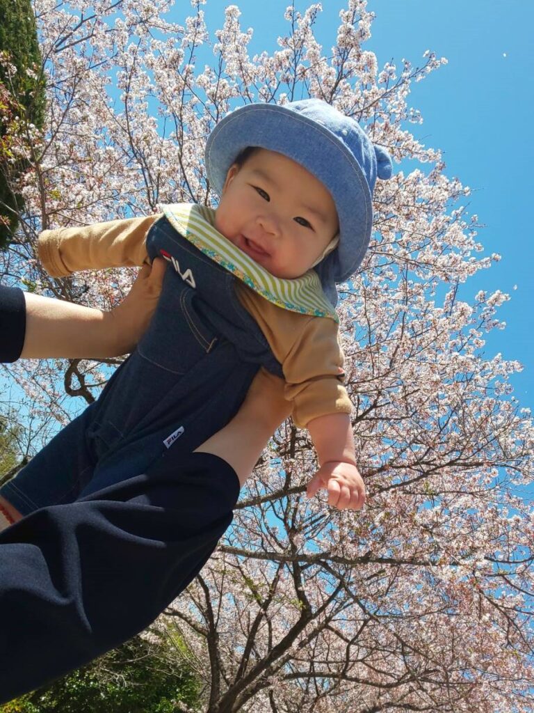 パパの母校の学校にお花見に行って、青々とした空と桜でにっこり