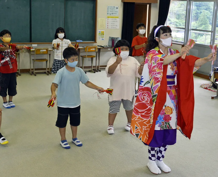 田中恵美子さんに正調よさこい鳴子踊りを教わる児童たち（いの町の長沢小学校）