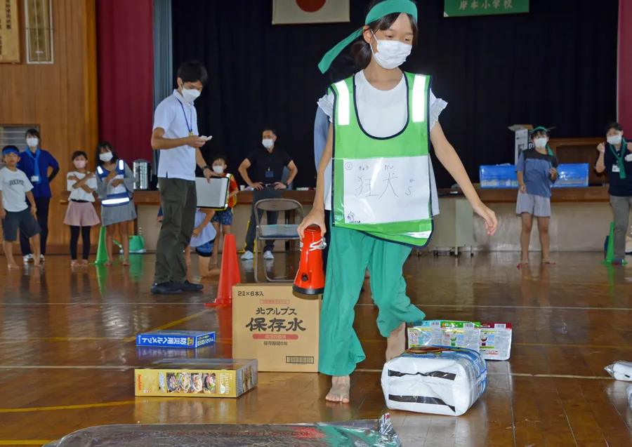 「避難所ジェスチャーゲーム」で物資を運ぶ子どもたち（香南市の旧岸本小学校）