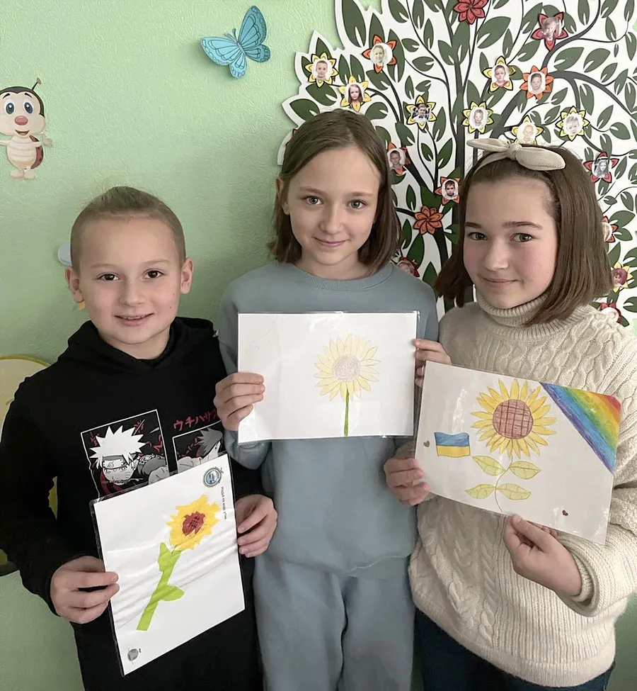 高知の子どもらから贈られた絵手紙を手にするウクライナの子どもたち（キーウの市立幼稚園・小学校「シャイヴォ」＝ヴィクトリア・カミンスカさん提供）
