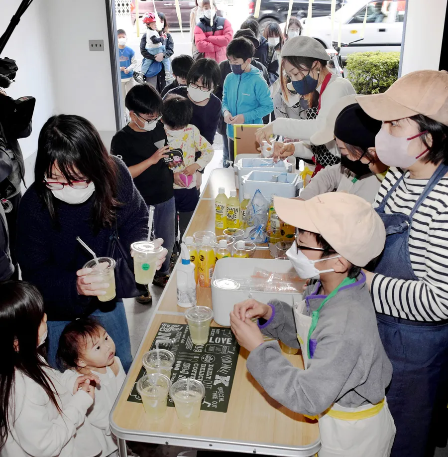 保護者やボランティアの手を借り、レモネードを提供する児童たち（高知市小津町）