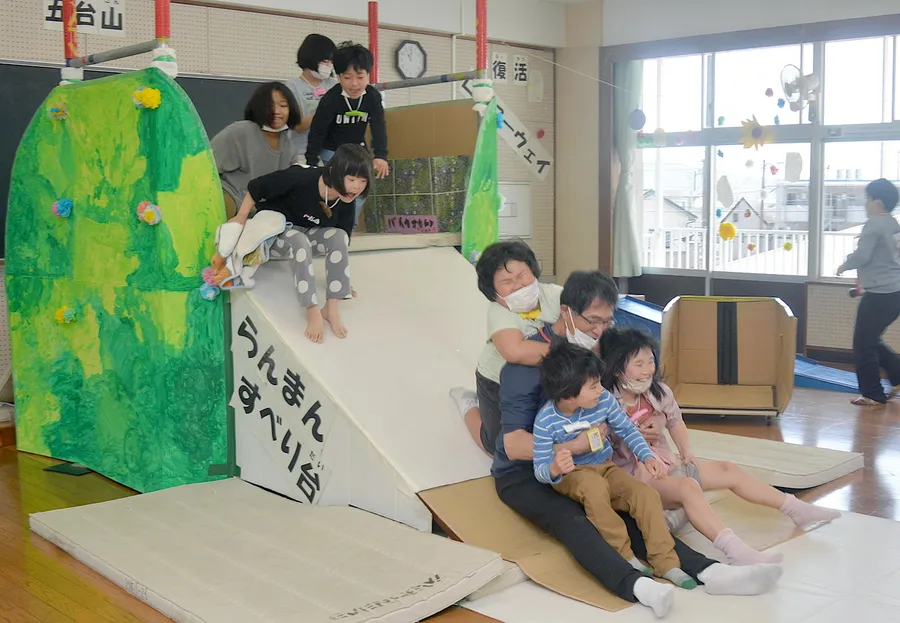 教室で大人気の「らんまんすべり台」。五台山をイメージして、児童が色を塗った。谷雄二教諭と一緒にすべって楽しむ（写真はいずれも高知市の一宮小学校）