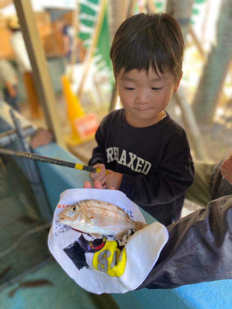 【はじめてのお魚釣り】桂浜水族館の釣り堀でお魚を釣りあげた時です。満足だけど、ちょっと緊張の面持ちです