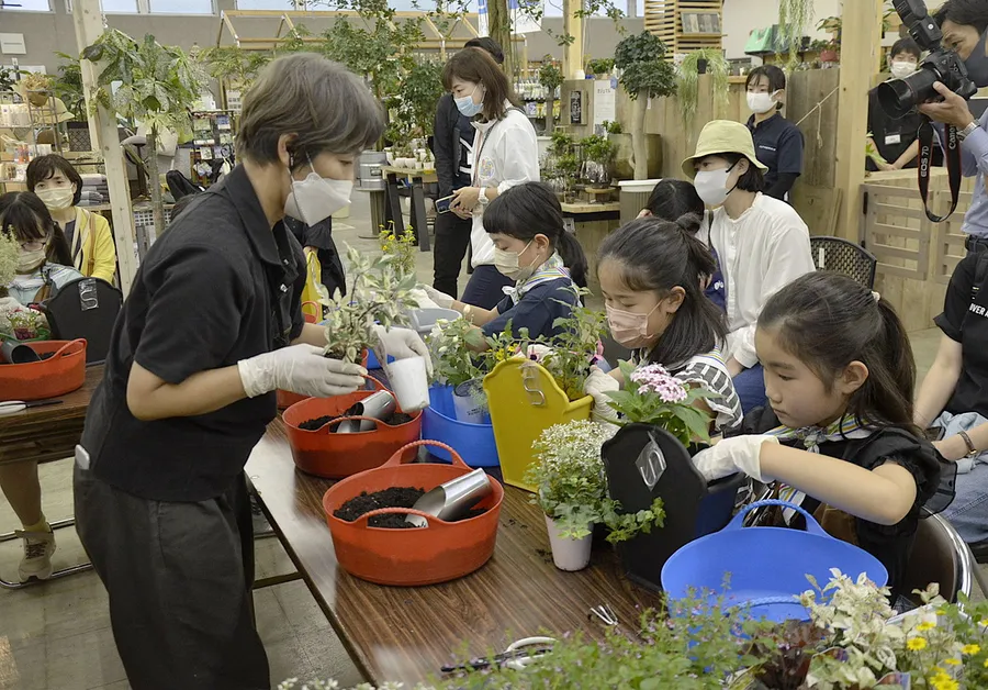 買い手の気持ちに立った花の寄せ植えに挑戦する児童（南国市のマルニガーデン）