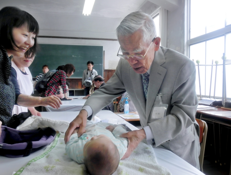 総合診査を担当する小児科医の浜田義文さん。1929年の第1回赤ちゃん審査会に赤ちゃんとして参加し、1960年からは小児科医として関わってきた先生です（2018年、高知会場）