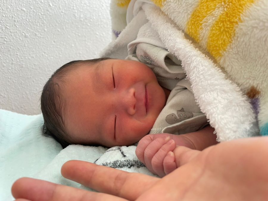 【はじめての笑顔】生まれた次の日、ママの手を握って微笑んでくれた思い出の写真です
