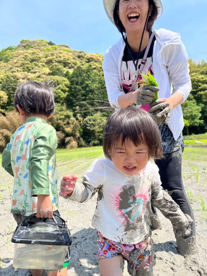 【はじめての田んぼで泥んこ遊び】楽しんでいる母や兄に対し、寝起きで慣れない泥の感触にこの表情