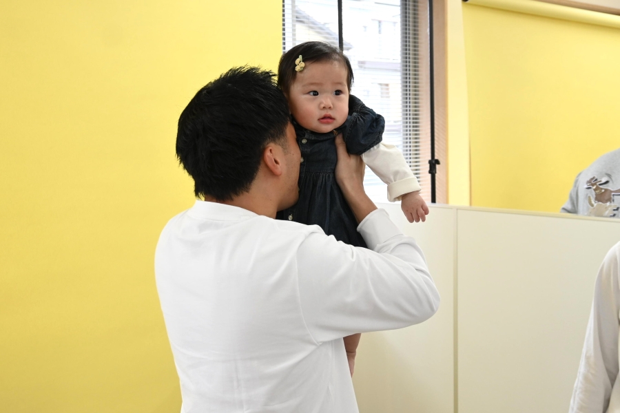 「笑ってー！」と頑張るお父さんと「どうしよっかなー」というお顔の娘さん