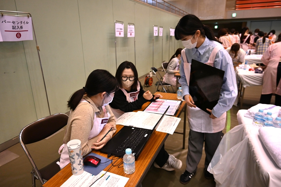 測定ブースの後ろでは学生たちが身長と体重から数値を計算していました