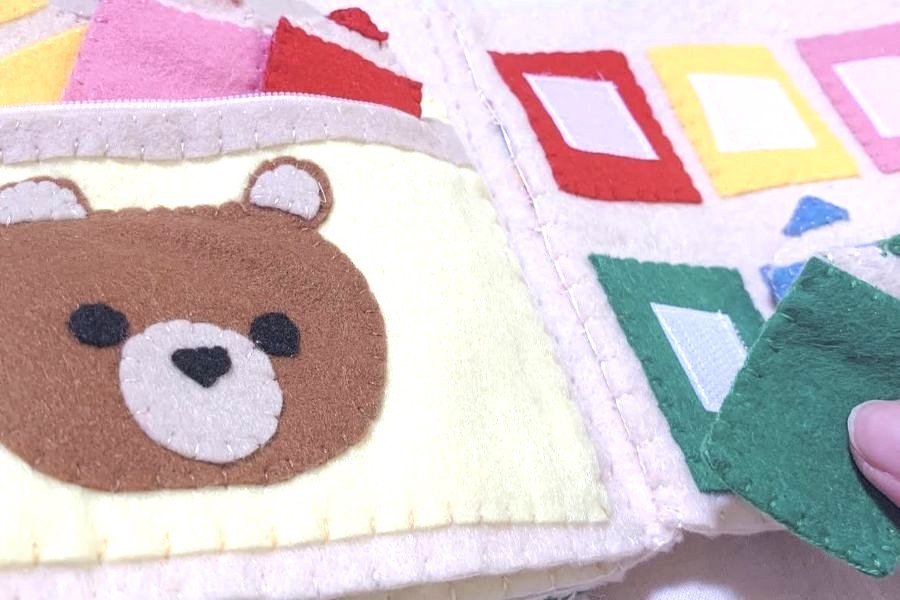 手作りの布絵本。布地をポケットに入れたり、ボタンを留めたりできます