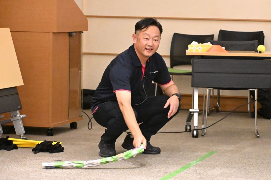 新聞紙を棒のようにして、床の近くで動かします